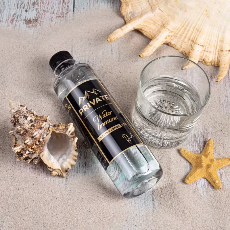 Бутилка PRIVATE Water Immune върху маса